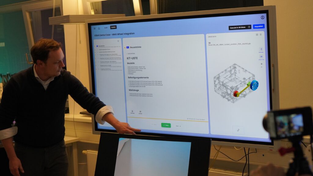 Sebastian Kottmeier (DLR) verdeutlicht im physischen Gegenstück zum digitalen Reinraum einen Demo Use Case für den Smart Service „Holo Work“.
