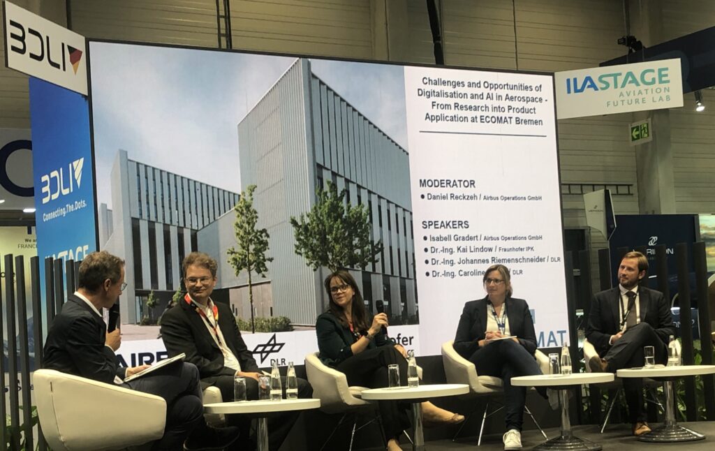 Das Panel zum Thema „Challenges and Opportunities of Digtialisation and AI in Aerospace – From Reasearch into Product Application at ECOMAT Bremen” auf der Aviation Future Lab Stage. V.l.n.r. : Daniel Reckzeh (Airbus Opeartions GmbH), Dr.-Ing. Johannes Riemenschneider (DLR), Dr.-Ing Caroline Lange (DLR), Isabell Gradert (Airbus Operations GmbH), Dr.-Ing Kai Lindow (Fraunhofer IPK), (© AVIASPACE BREMEN e.V./ Julian Hofhans).
